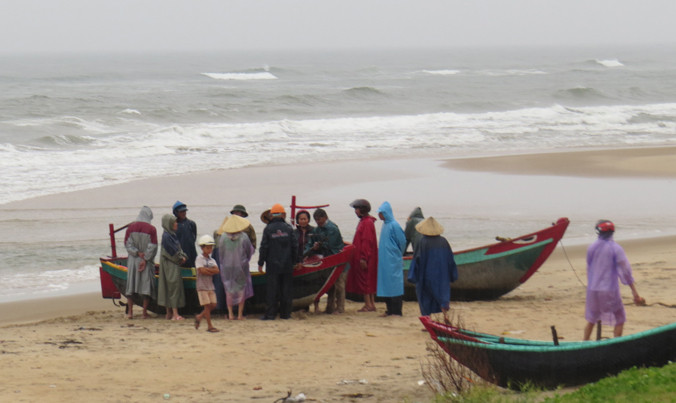 Người dân và lực lượng cứu hộ trên bờ tập trung tại bờ biển xã Hải Trạch sáng nay để đón những ngư dân bị nạn vào bờ.