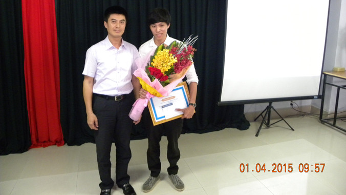 Ông Lê Hoàng Dũng trao học bổng cho Lê Doãn Ý (bìa trái).