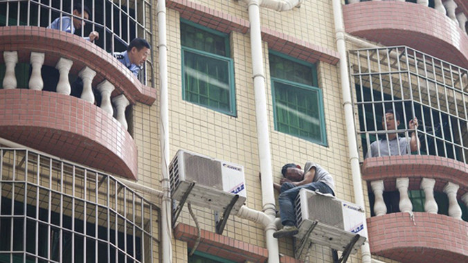 Tên trộm ngồi vắt vẻo trên bộ lọc máy điều hòa suốt 40 giờ. Ảnh: Shanghaiist.