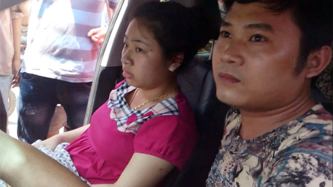  Nam tài xế và cô gái tình nghi ăn cắp hộp đựng thẻ điện thoại ngồi lì trên xe. Ảnh: Tuấn Nguyễn