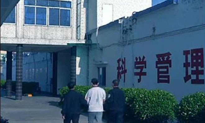 Li bị an ninh Quảng Đông dẫn giải vào phòng xử án. Ảnh: Sohu