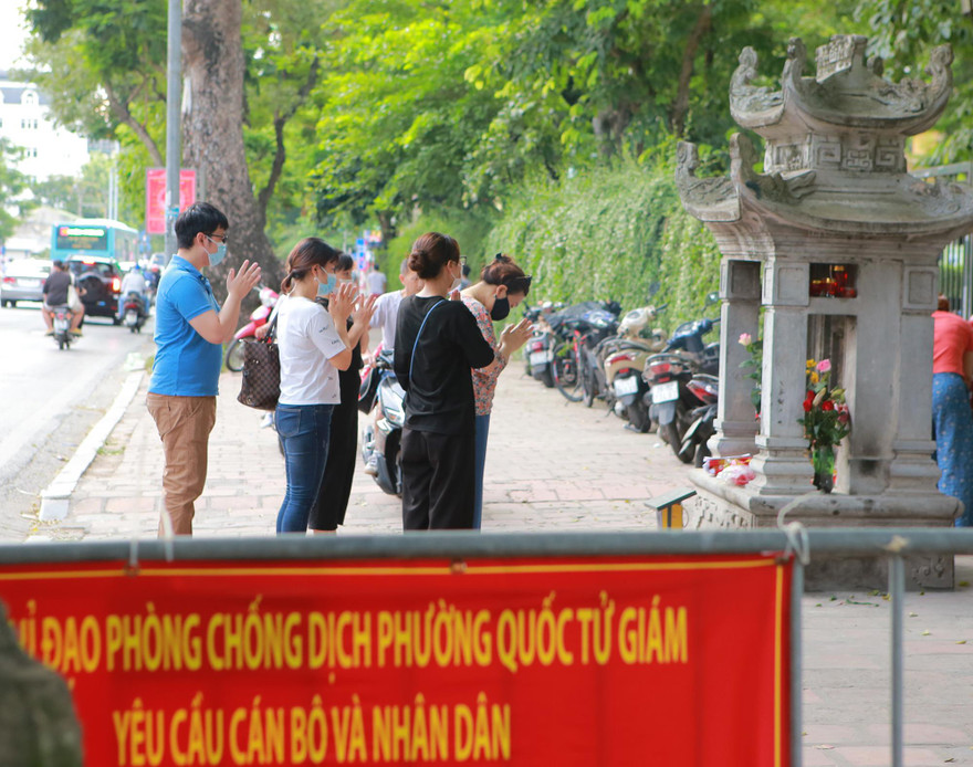 Sĩ tử và người dân kéo về vái lạy cầu may trước tấm "biển báo giao thông" ở Văn Miếu. Ảnh: Trọng Tài