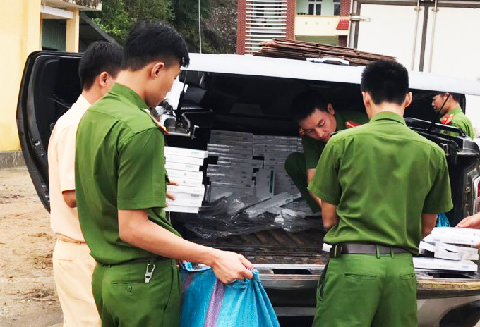 Lực lượng chức năng kiểm đếm số lượng thuốc lá chưa rõ nguồn gốc. Ảnh Văn Phương