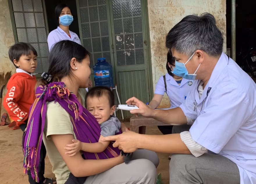 Bác sĩ kiểm tra thân nhiệt của các em nhỏ ở xã Hải Yang