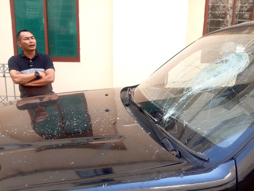 Kính trước xe ô tô bán tải của ông Thanh bị đập vỡ.