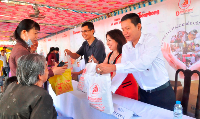 Đại diện báo Tiền Phong tại TPHCM – Nhà báo Lý Thành Tâm cùng vợ chồng ông Nguyễn Ngọc Lang, Tổng giám đốc Cty Mỹ Phẩm Đăng Dương trao quà cho bà con. Ảnh Việt Văn.