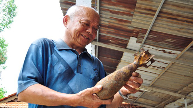 Ông Nguyễn Tú Lâm bên quả đạn cối sưu tầm được. Ảnh: Ngọc An/ Zing