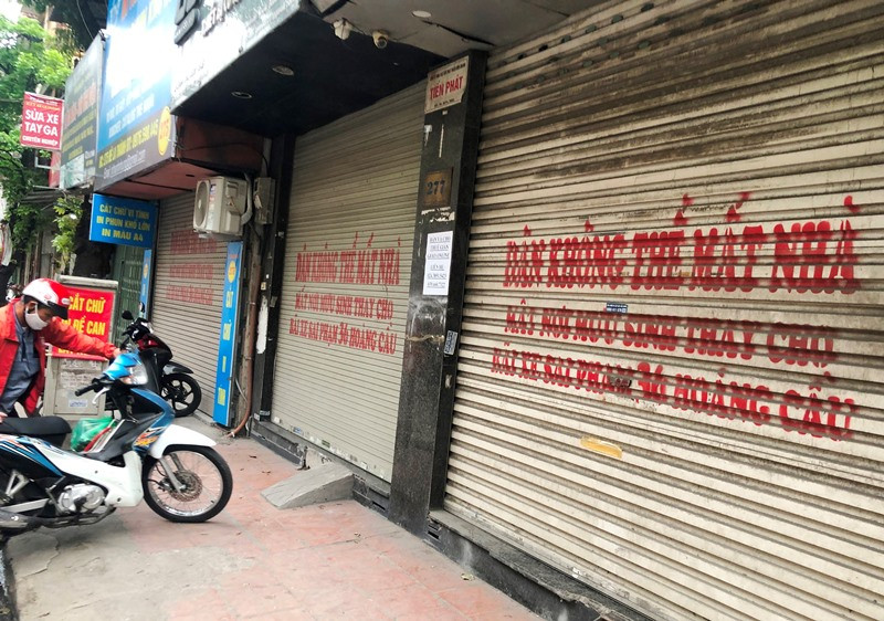 Những ngày qua nhiều cửa hàng trên đường Đê La Thành đã in chữ trên cuốn để phản đối việc lấy đất để làm bãi đỗ xe, cây xanh-một hạng mục của dự án đường Vành đai 1 đoạn Ô Chợ Dừa - Voi Phục (Cầu Giấy).