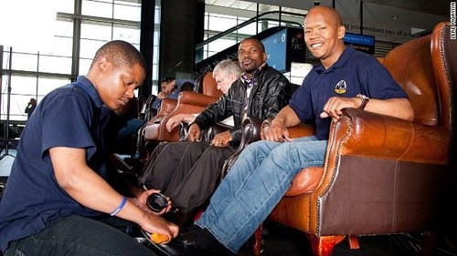 Trên con đường thành triệu phú, Lere Mgayiya (bên trái) đã có ngày khởi đầu khó khăn khi chỉ có chiếc ghế đôn thay vì ghế salon cho khách hàng. 