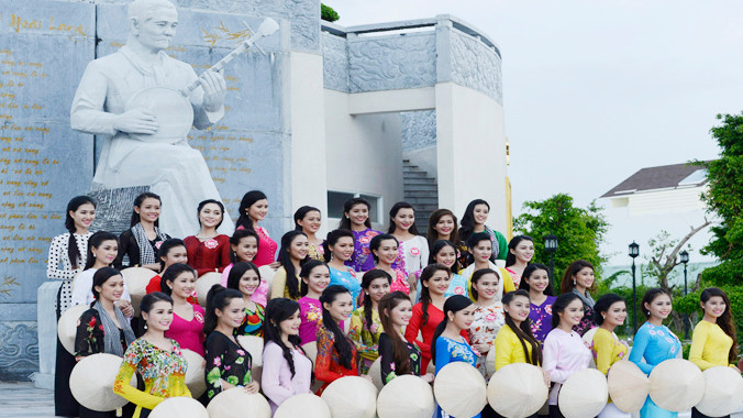 Các thí sinh trước tượng nhạc sỹ Cao Văn Lầu, tác giả bài Dạ cổ hoài lang. Ảnh: Nguyễn Sơn