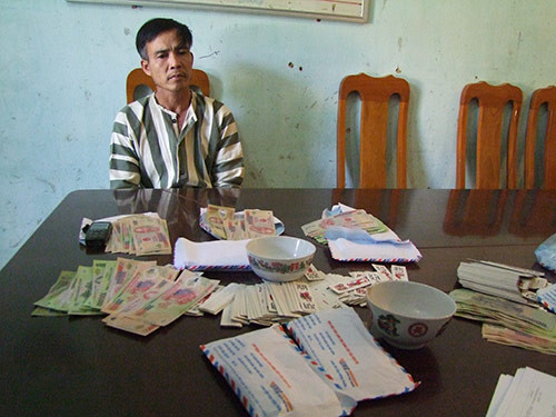 Lý Văn Đại và số tiền đánh bạc bị công an thu giữ. Ảnh: Chung Kiên.