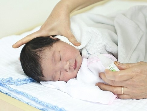 Dùng nước muối sinh lý để vệ sinh mũi cho trẻ.