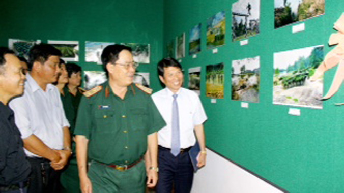 NSNA Vũ Quốc Khánh- Chủ tịch Hội NSNA Việt Nam cùng Trung tướng Đinh Văn Cai, Chính ủy Quân khu 9 và đại biểu tham quan triển lãm. Ảnh: Dương Thu
