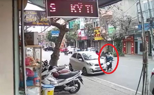 Người phụ nữ mở cửa xe bất cẩn khiến 2 em học sinh ngã xuống đường. Ảnh cắt từ clip.