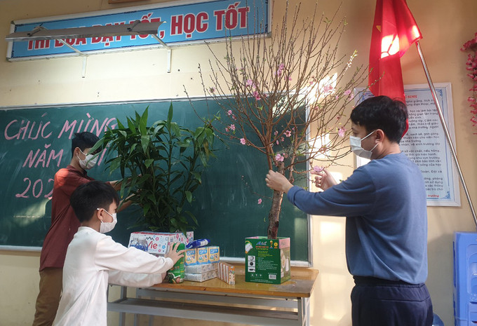 Anh Nguyễn Duy Long cùng hai con trai trang trí phòng cách ly để đón Tết. Ảnh: Nhân vật cung cấp.