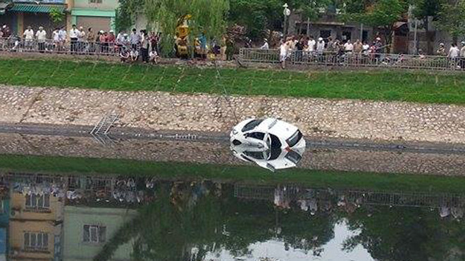 Chiếc taxi húc bay lan can lao xuống sông Tô Lịch.