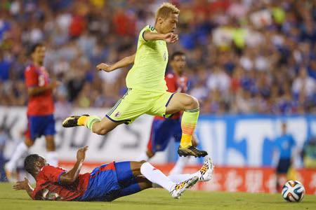Tiền vệ Keisuke Honda (trên, Nhật) tránh cú tắc của hậu vệ Costa Rica.