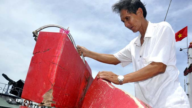 Thuyền trưởng Trần Văn Kỳ bên mũi tàu QNa 90448 bị tàu Trung Quốc đâm biến dạng