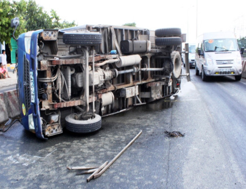 Xe tải chở nước mắm lật ở quận Bình Tân (TP HCM) sáng 26/7. Ảnh: Hải Thuận/VnExpress