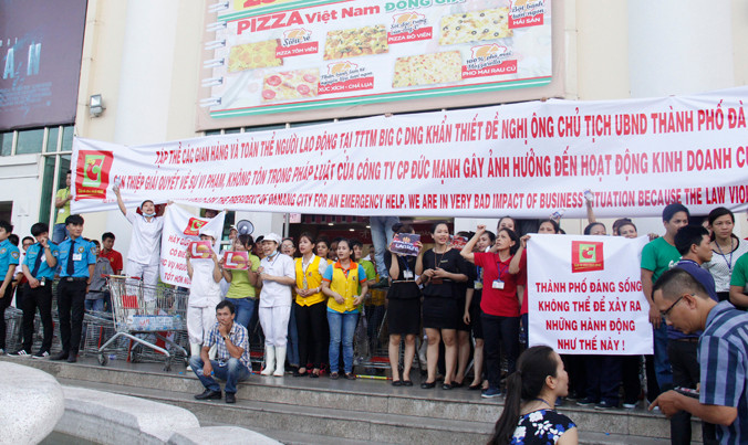 Hàng trăm nhân viên siêu thị Big C giăng biểu ngữ, tụ tập phản đối hành vi cản trở hoạt động kinh doanh của Công ty Cổ phần Đức Mạnh. Ảnh: Thanh Trần.
