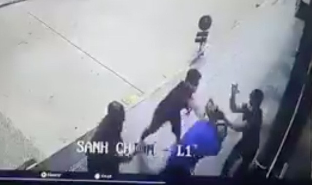Anh H. (áo xanh) bị các đối tượng vây đánh. Ảnh cắt từ clip