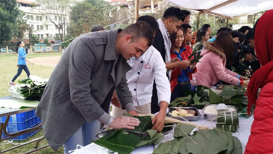 Sinh viên Việt Nam và du học sinh nước ngoài tại Việt Nam cùng nhau gói bánh chưng.