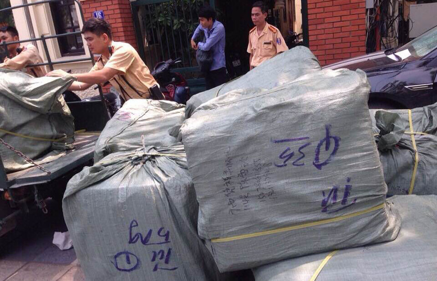 Hơn 200 chiếc cặp sách da màu nâu chở trên xe bị CSGT phát hiện.