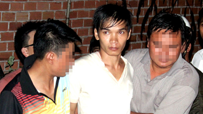 Vũ Văn Tiến, người được cho là nghi can vụ thảm sát được nhà chức trách dẫn đi. Ảnh: Duy Thắng.