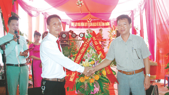Ông Vũ Minh Khôi, Giám đốc Công ty TNHH đồ gỗ mỹ nghệ Minh Khôi (bên trái) đón nhận chúc mừng từ đối tác 