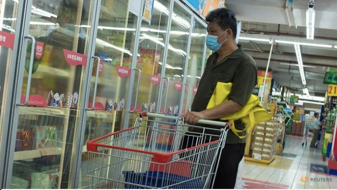 Một người đàn ông nhìn tủ chứa thực phẩm đông lạnh trong siêu thị ở Bắc Kinh. (Ảnh: Reuters)