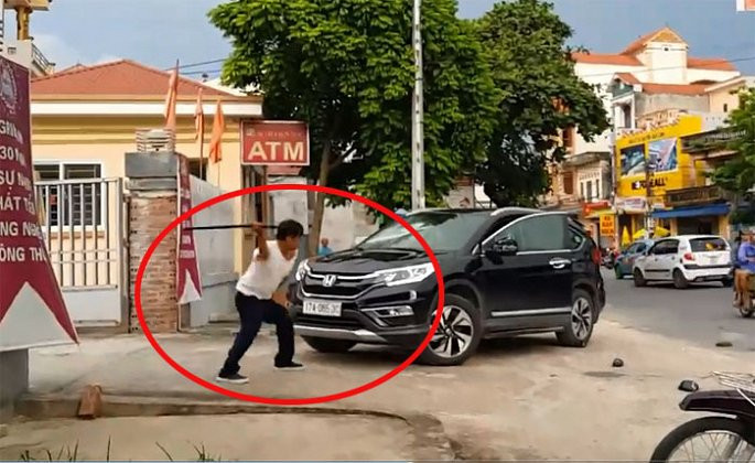 Một bảo vệ dùng vật giống kiếm liên tiếp đập chiếc xe ô tô trước cổng ngân hàng.