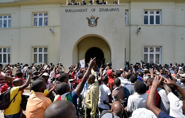 Người dân Zimbabwe tập trung nghe lá thư từ chức của ông Mugabe. Ảnh: 