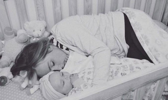 Bức ảnh người mẹ nằm trong cũi cùng con đang được chia sẻ khắp thế giới.