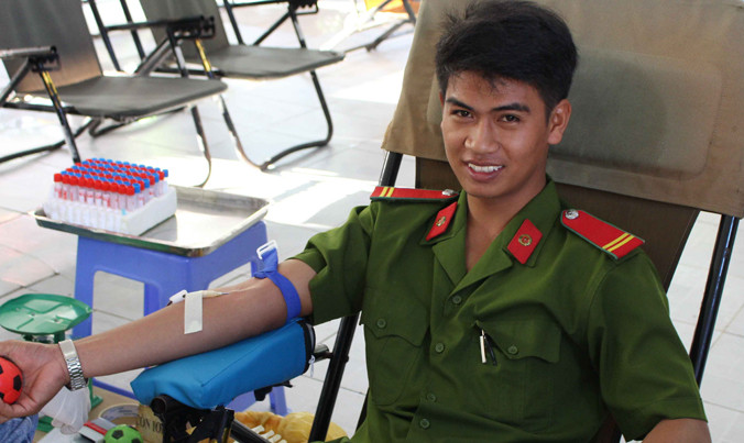 Chiến sỹ công an tươi cười hiến máu.