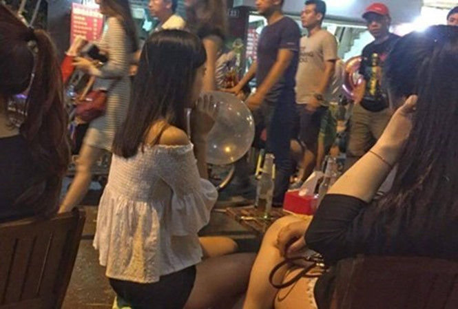 Thanh niên hút bóng cười ở phố cổ Hà Nội. Ảnh: Trần Hoàng