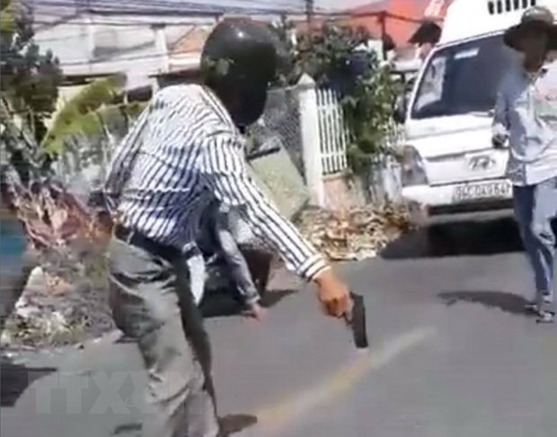 Ông Huỳnh Văn Đài cầm vật nghi là súng đe dọa người va chạm giao thông với ông. (Ảnh: TTXVN phát)