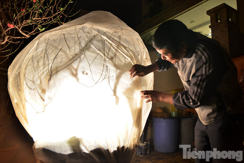 Ông Đức cho biết, những cây đào này được chúm kín nilon và thắp đèn sưởi suốt đêm thúc hoa nở nhanh hơn kịp bán dịp Tết. Ảnh: Thanh Hà.