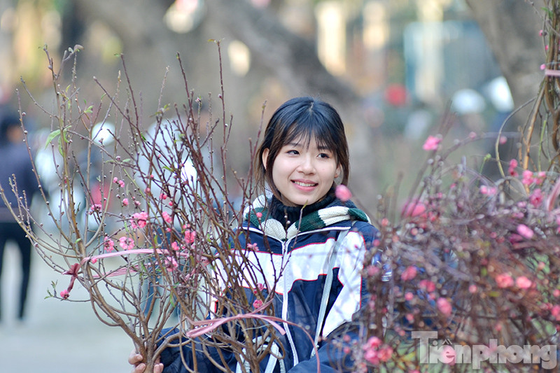 Chiều 29 Tết, trên các tuyến phố, chợ hoa, bờ Hồ nhiều người tranh thủ chụp ảnh, mua sắm, bán nốt những cành đào, chậu quất,... chuẩn bị về sum vầy bên gia đình.