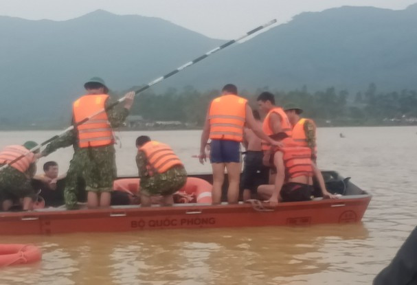 Lực lượng chức năng tìm vớt thi thể em Phúc trên cánh đồng nước lũ vẫn dâng cao. Ảnh: Báo Nghệ an 