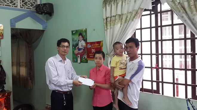 Đại diện báo Tiền Phong trao tiền hỗ trợ cho gia đình anh Đinh Văn Đồng. Ảnh Ngọc Trường