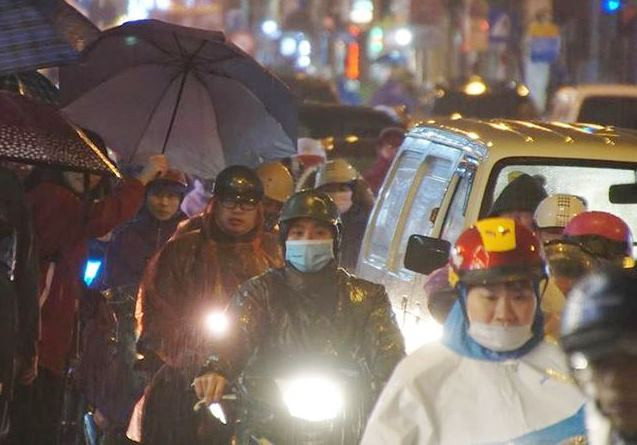 Nhiều người chôn chân, co ro đứng dưới vì ùn tắc trên đường chiều tối nay. Ảnh: Mạnh Thắng