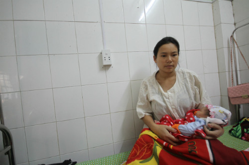 Chị Thành cùng cô con gái vừa chào đời mang ơn người anh em họ đã xả thân cứu mình. Ảnh: Nguyễn Đông.