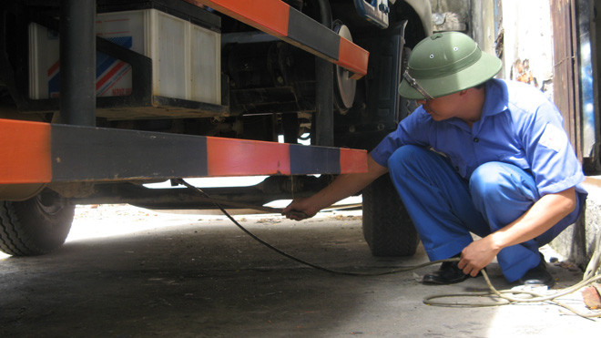 Kỹ thuật viên đang kiểm tra xe đăng kiểm tại một Trung tâm đăng kiểm phía Bắc. ảnh: Phạm Anh