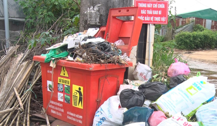Rác đầy ứ bên trong và chất đống bên ngoài thùng