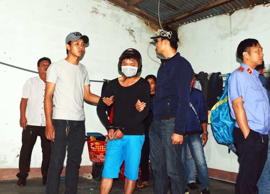 Vũ (đeo khẩu trang) tại hiện trường vụ án