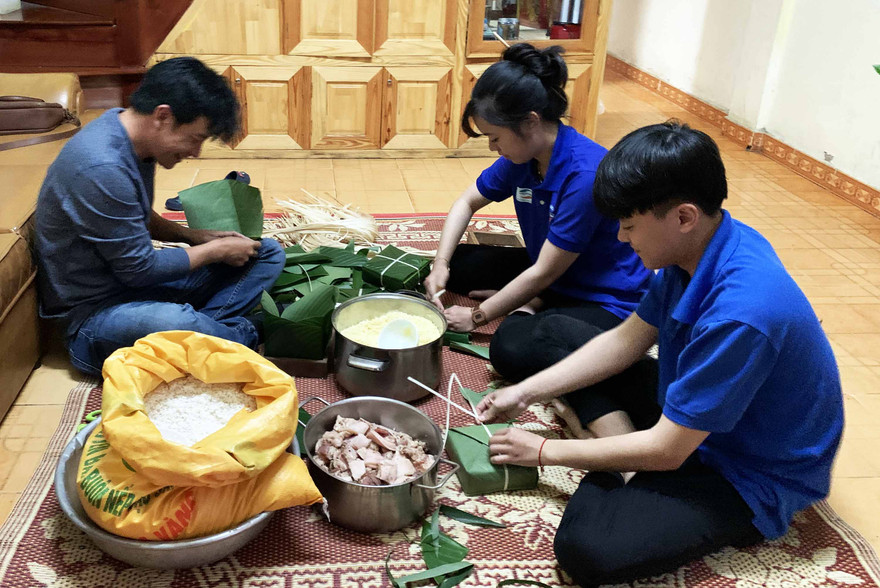 Các bạn trẻ hối hả gói bánh chưng.