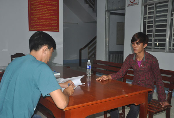 Đối tượng Luân (áo ca-rô đỏ) đang được cơ quan Công an lấy lời khai