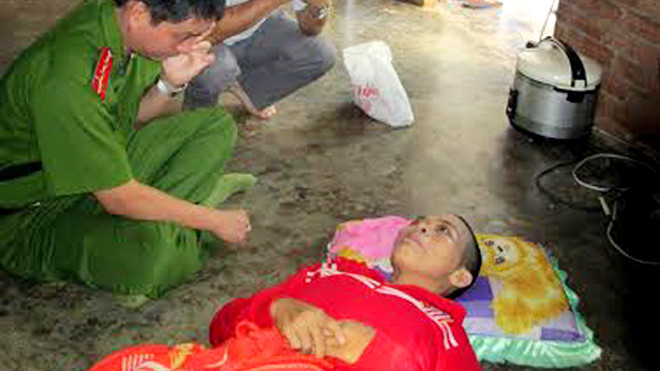 Cán bộ điều tra đang lấy lời khai mẹ của hai đứa trẻ bị tiêm thuốc độc. Ảnh: Xuân Mai