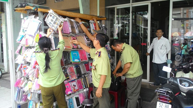 Lực lượng Quản lý thị trường đồng loạt ra quân kiểm tra các cửa hàng kinh doanh phụ kiện ĐTDĐ. Ảnh Việt Văn.