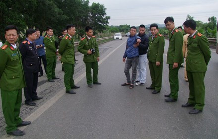 Hoàng Văn Trường (áo xanh) được dẫn giải đến hiện trường để phục vụ quá trình điều tra.